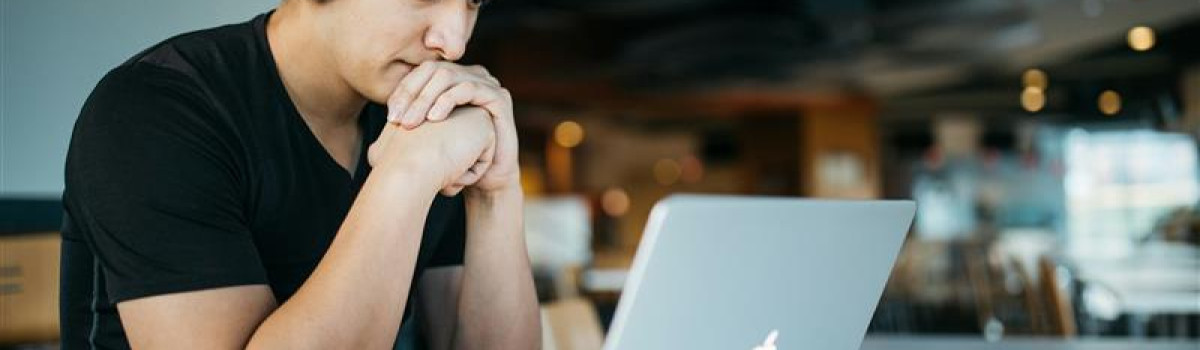 jeune homme assistant à un webinar, casque et ordinateur portable